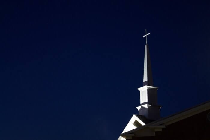 white church steeple against dark blue sky
