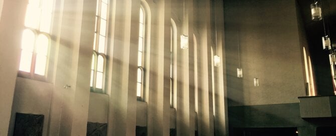 Dark church with light shining through windows